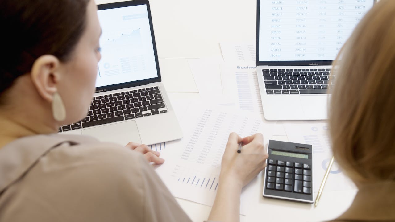 A Person Writing on a Paper with Graph A Person Writing on a Paper with Graph<br />